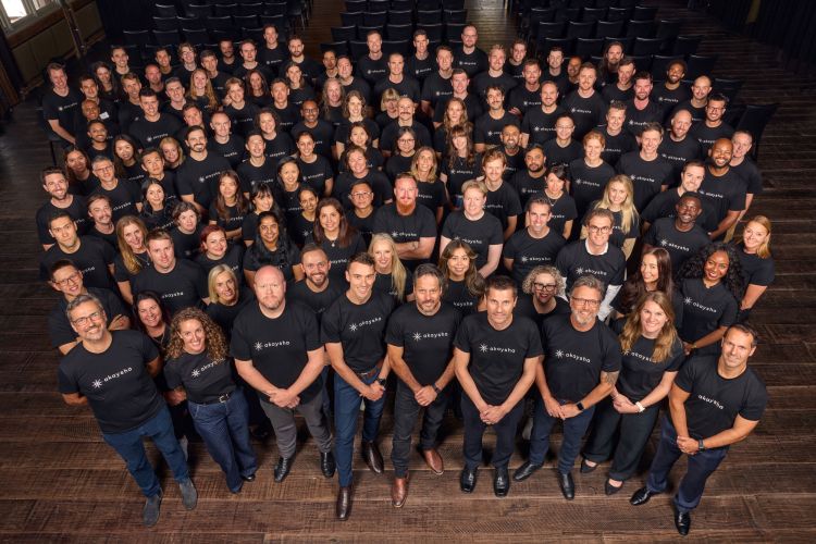 A young asian woman sitting at a small white table talking to a young black woman who has her back to the camera